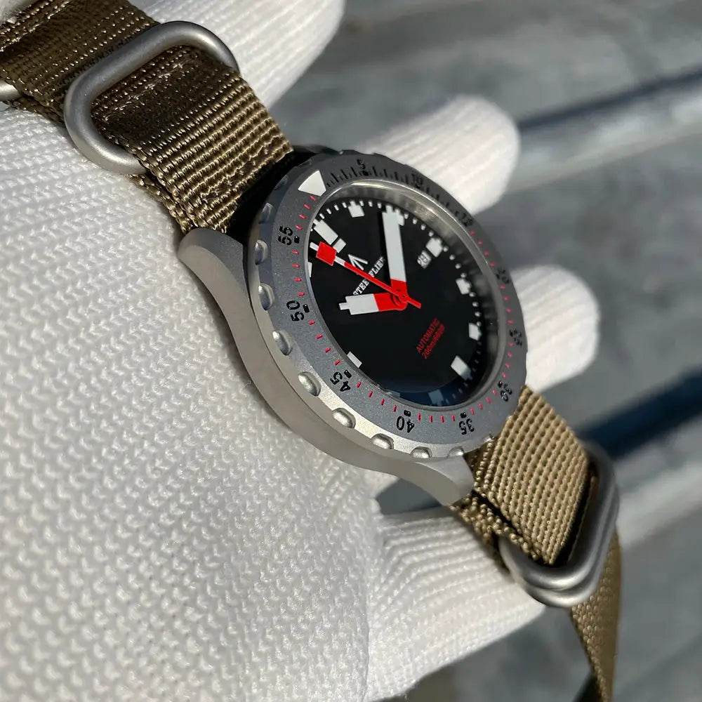 STEELFLIER SF752 mechanical dive watch with grey case, black dial, white markers, red hands, and khaki nylon strap.