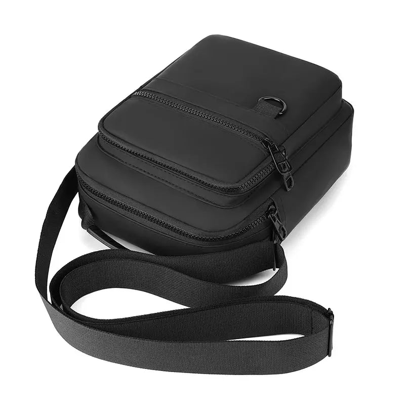 Messenger sling bag in black with multiple zip pockets and an adjustable strap