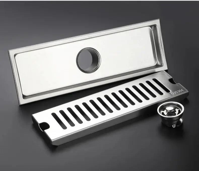 Long rectangular bathroom floor drain in SUS304 stainless steel with removable slotted grate and lid.