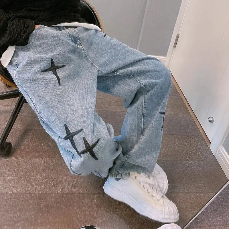 Men's light-wash denim cargo pants with black star patches, loose straight fit