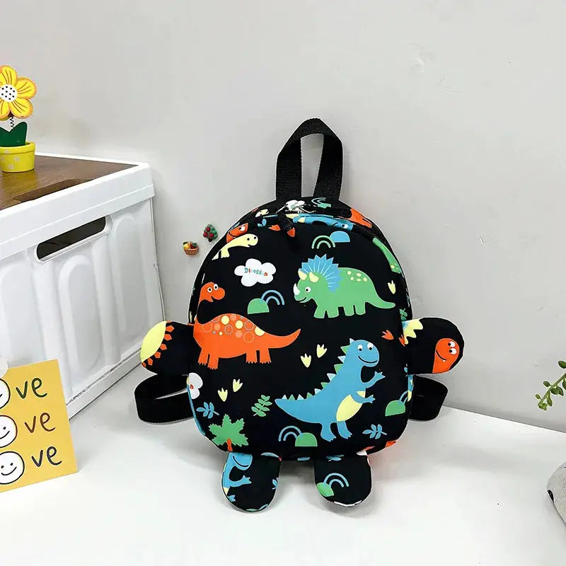 Dinosaur kids backpack with black fabric and colorful dinosaurs; kid-sized school bag by Simples Market.