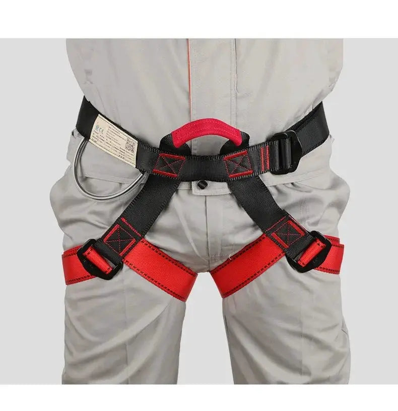 Rock climbing half-body safety harness by Simples Market; black straps with red leg loops and metal D-ring