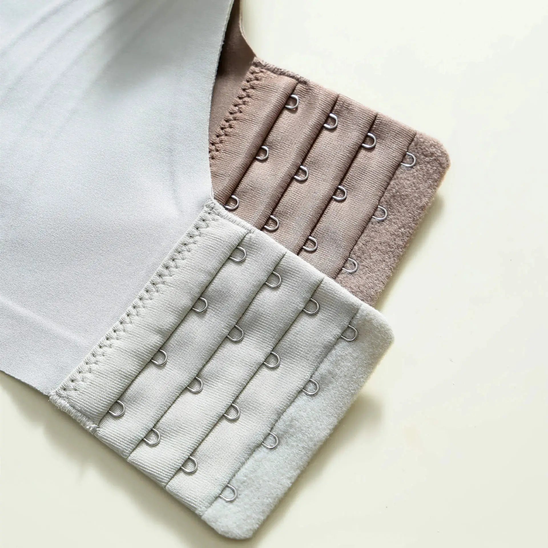 Bra hook-and-eye closure bands; five neutral colors stacked