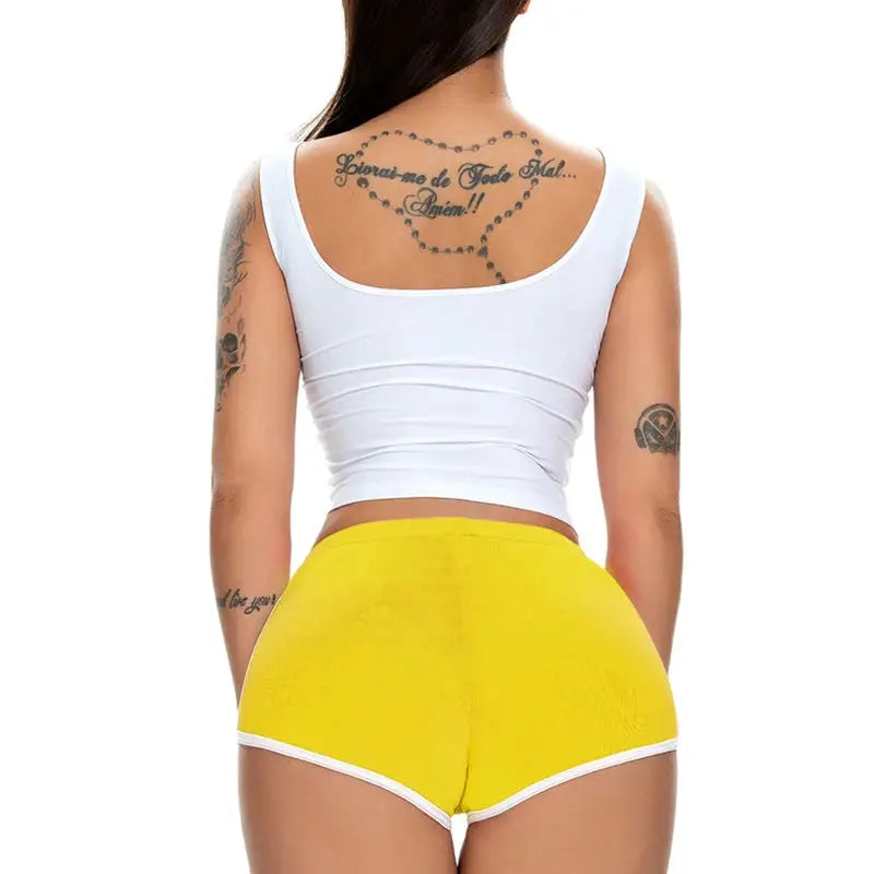 Women's yellow hot pants with white trim, back view of model wearing a white sleeveless top