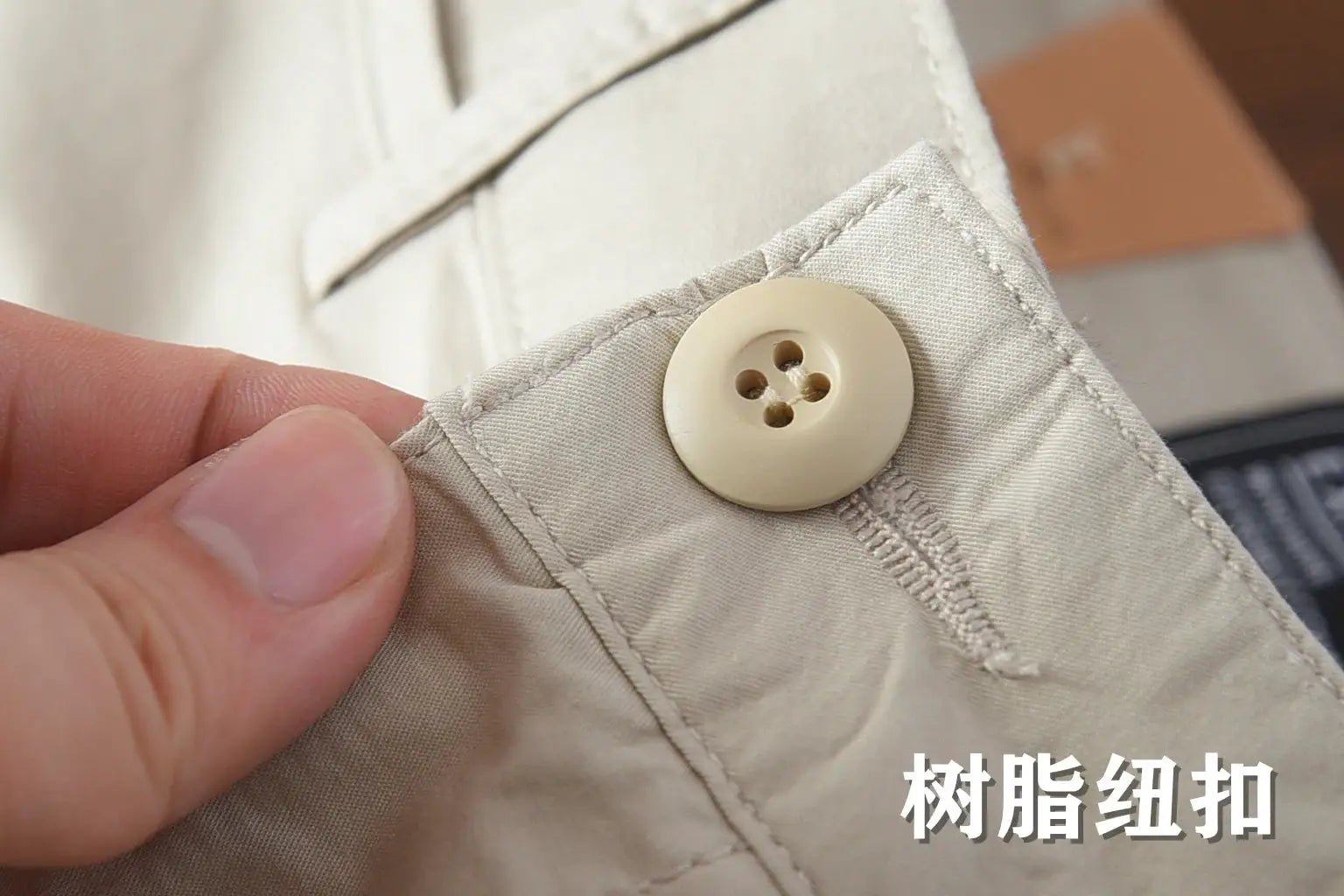 Beige men's chino pants close-up of a resin button on cotton fabric