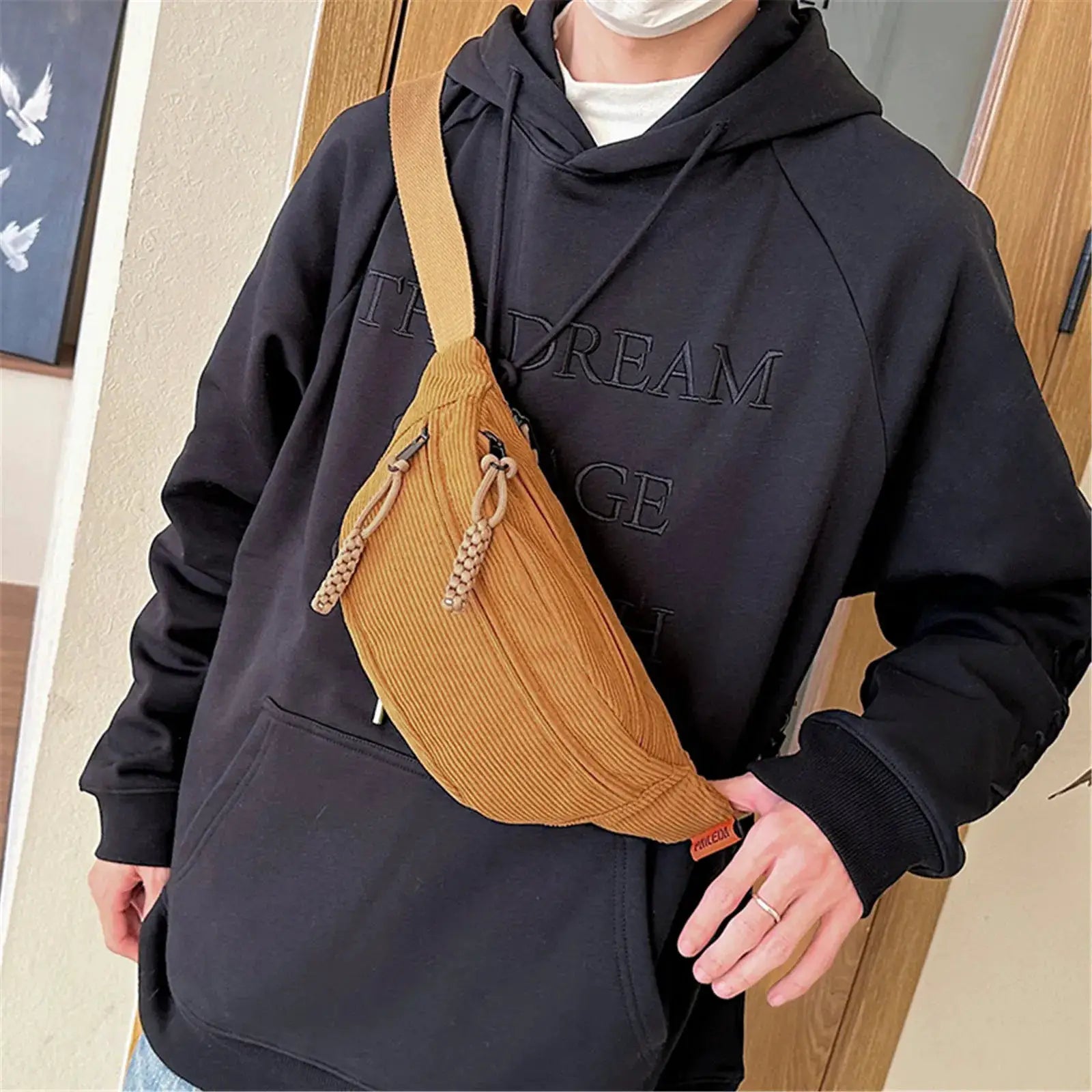 Tan corduroy belt bag worn crossbody over a black hoodie with a cord pull and wide strap, Simples Market fanny pack.