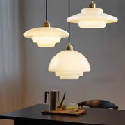 Nordic glass pendant lamp set: three warm-white glass pendants with brass fittings over a dining table