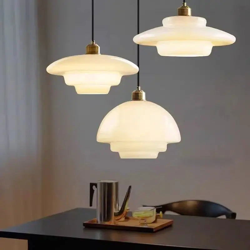 Nordic glass pendant lamp set: three warm-white glass pendants with brass fittings over a dining table