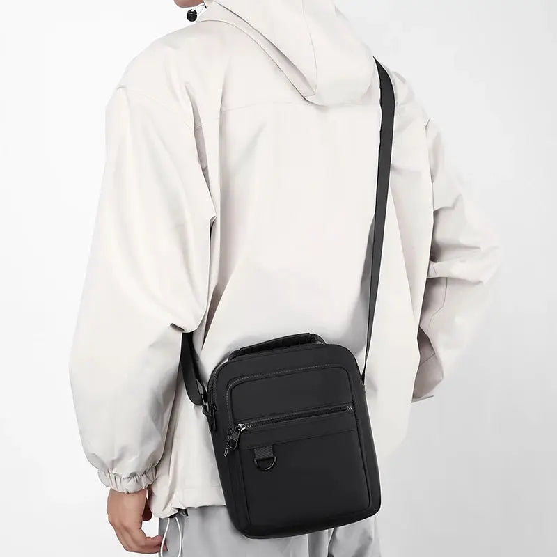 Messenger sling bag for men, black compact crossbody pouch with multiple zip pockets.