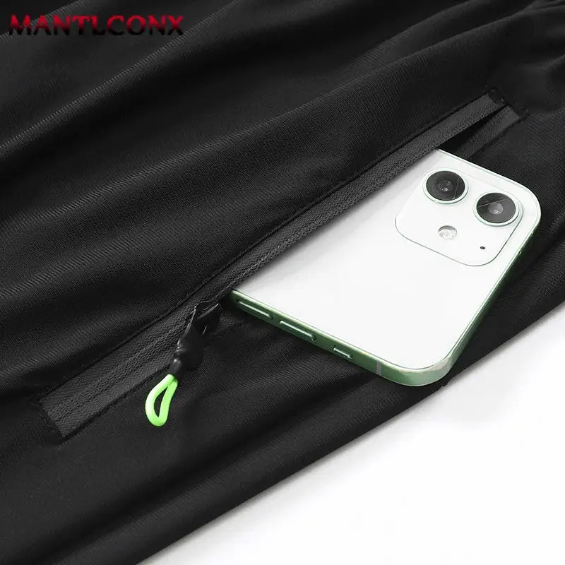 Men's black sports shorts with a neon-green zippered side pocket holding a smartphone
