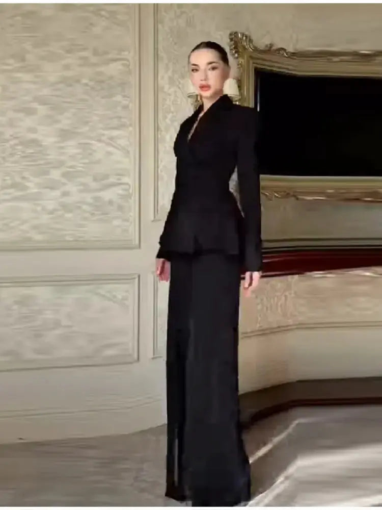 Black blazer and wide-leg pant suit set worn by model with lapel and peplum waist for a chic party look