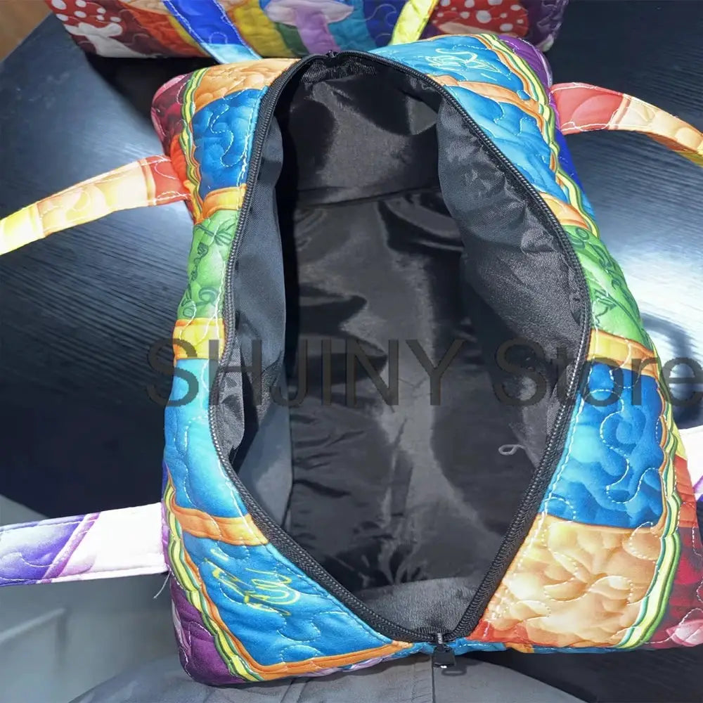 Simples Market quilted duffle bag with rainbow patchwork exterior and black interior.
