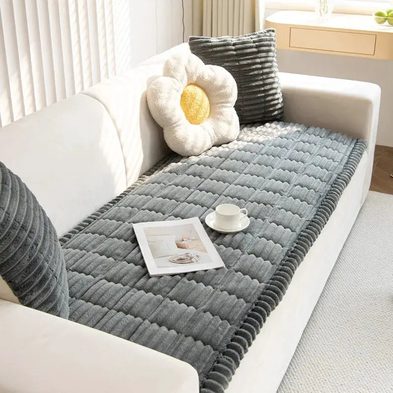 Thick quilted stripe flannel sofa pad by Simples Market in gray on a white sofa.