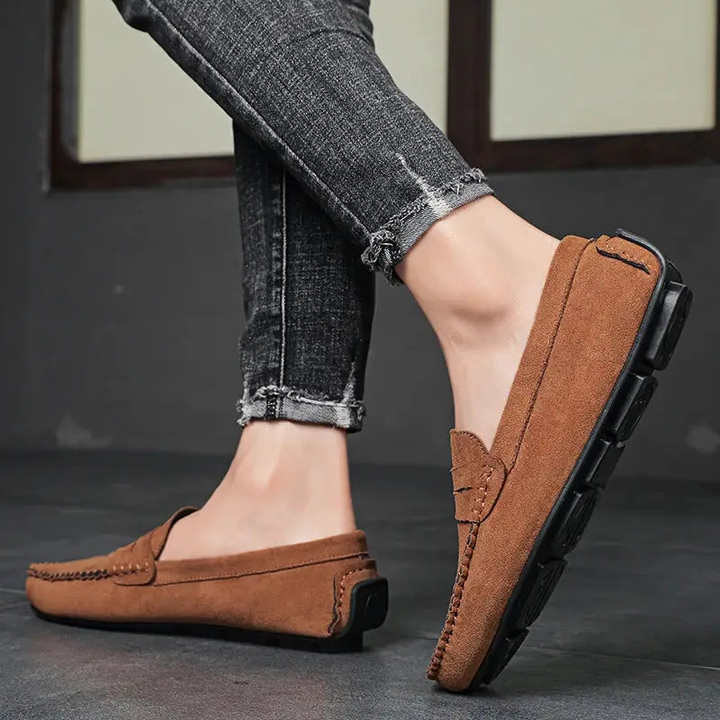 Pair of brown suede men's slip-on driving loafers with black rubber sole