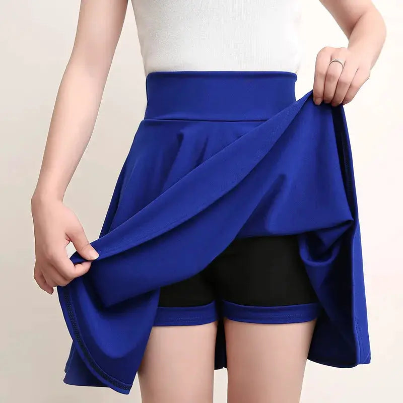 Simples Market blue flared skirt with attached black shorts; model holds the skirt to reveal the shorts