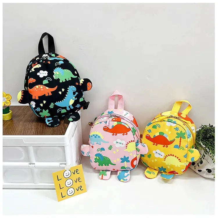 Dinosaur backpacks for kids in black, pink and yellow; three cartoon backpacks with anti-lost design