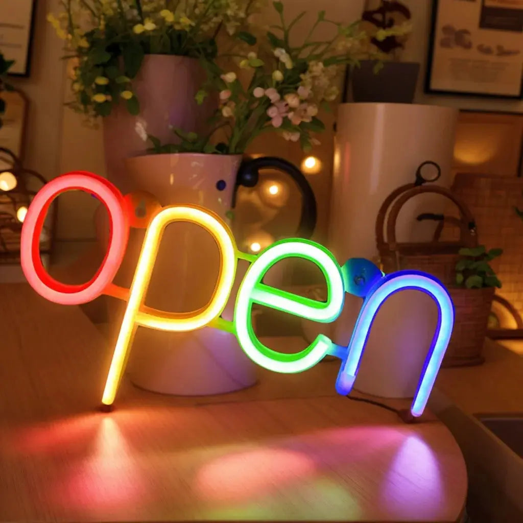Open neon sign in rainbow colors, decorative tabletop light for modern art ambiance.