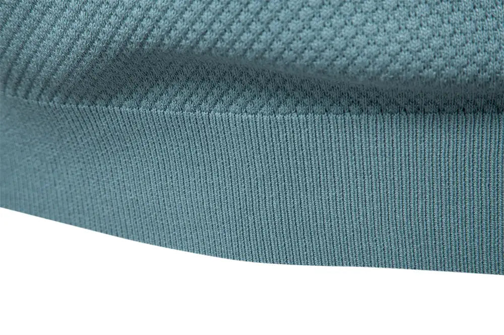 Men's golf polo shirt in teal knit fabric, close-up.