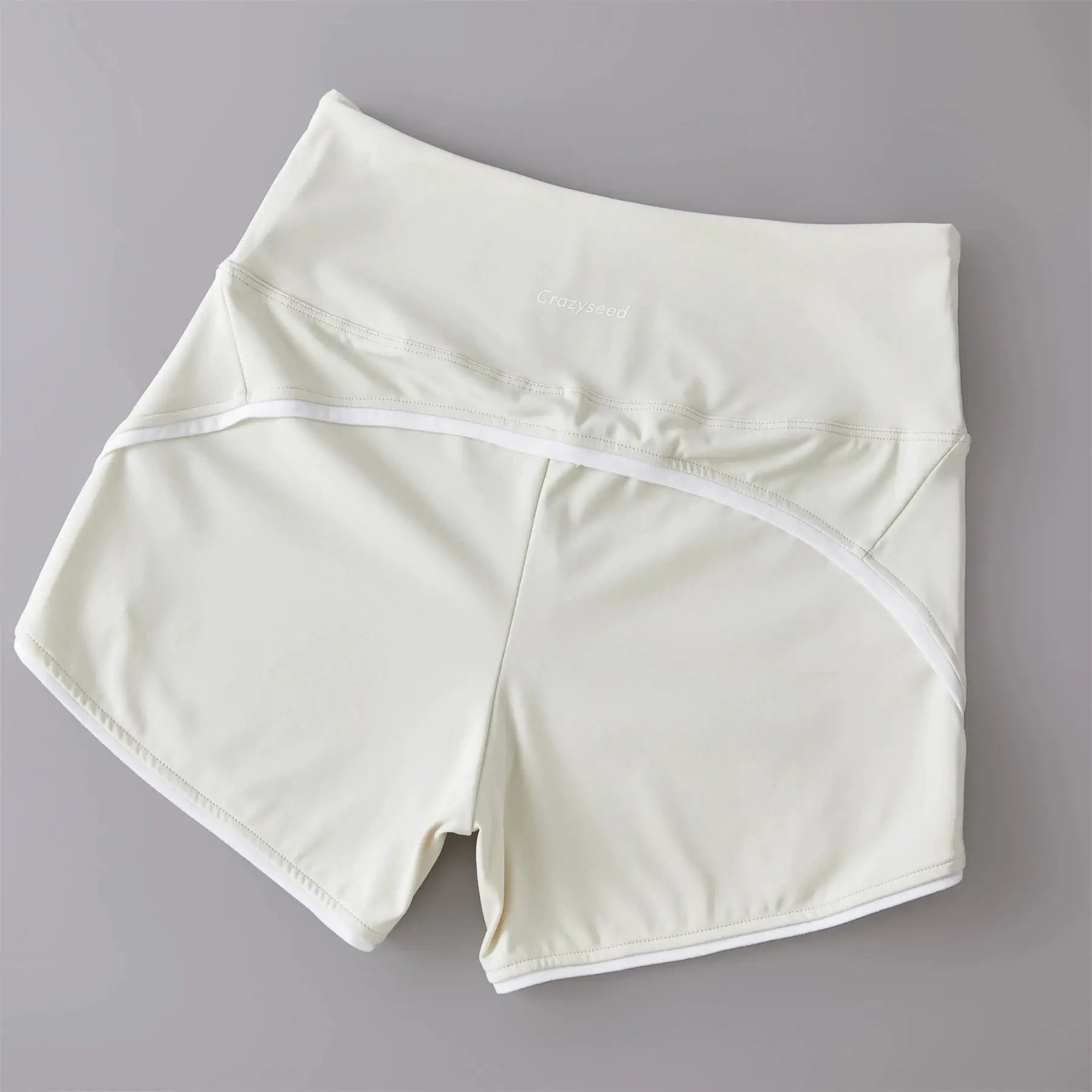 White high-waist athletic shorts with elastic waistband and Crazyseed branding