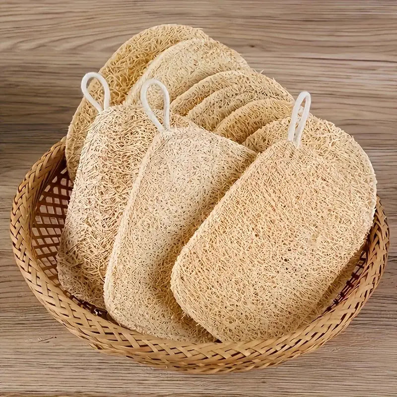 6pc natural loofah exfoliating sponges with white hanging loops in a woven basket