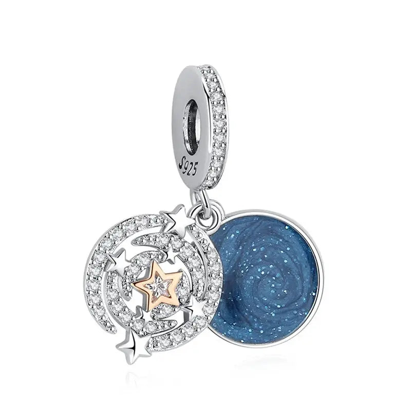Sterling silver charm with crystal-studded crescent and stars encircling a blue glitter round pendant