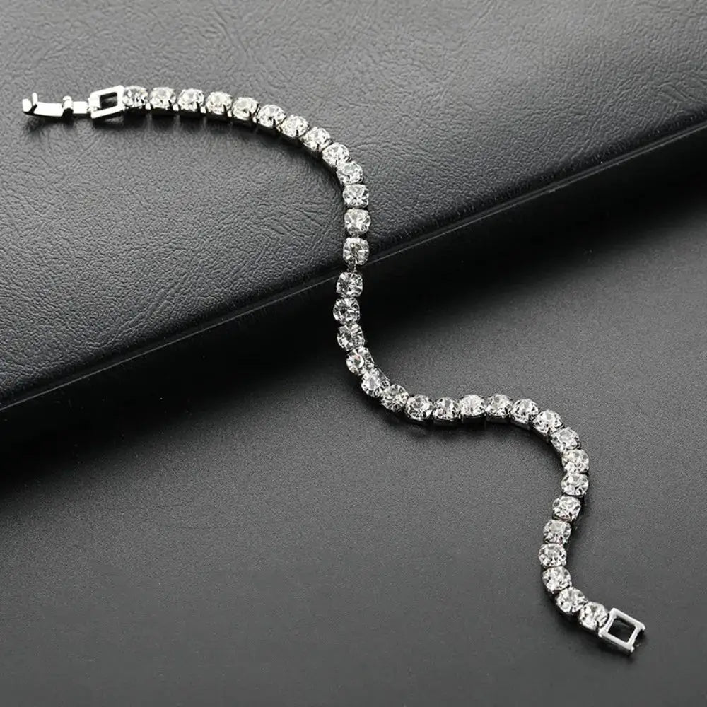 Bracelet with clear crystal zircon stones on a silver-tone zinc alloy chain, unisex tennis style.