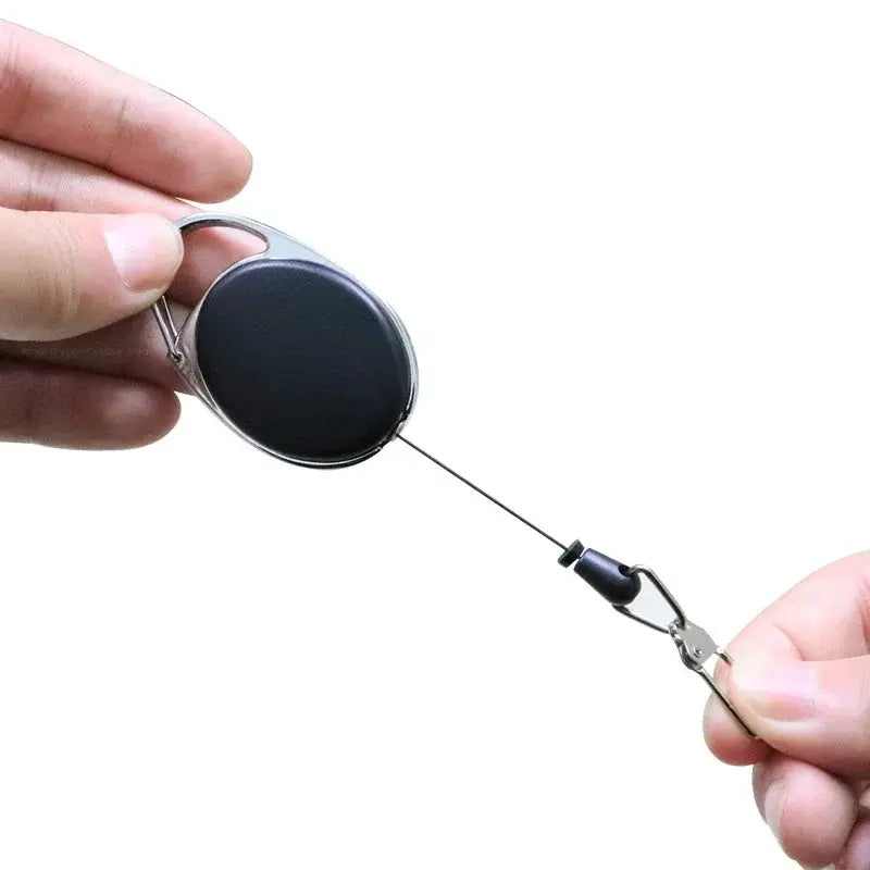 Fly fishing zinger retractable badge reel with black circular housing and quick-release clip