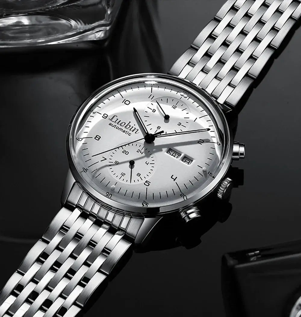 Mens stainless steel automatic wristwatch with silver dial, chronograph subdials and date window.