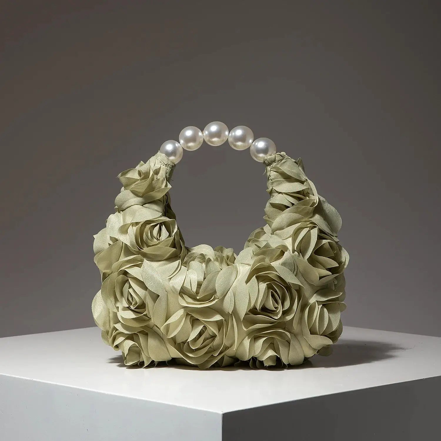 Cartera para mujer crema con rosas de tela y asa de perlas blancas.