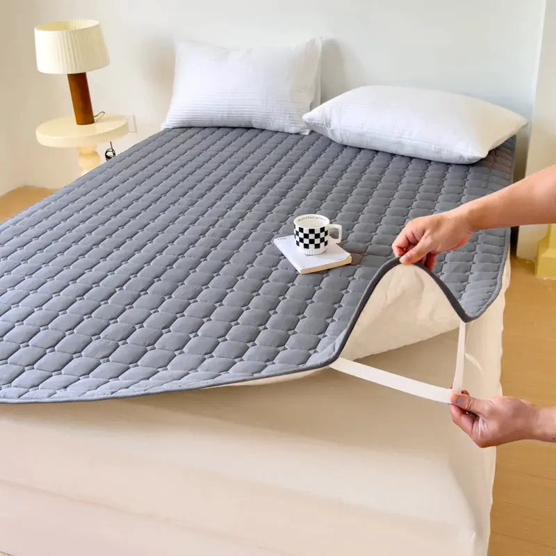 Waterproof quilted mattress protector topper in grey; thickened, breathable, fits single or double bed.
