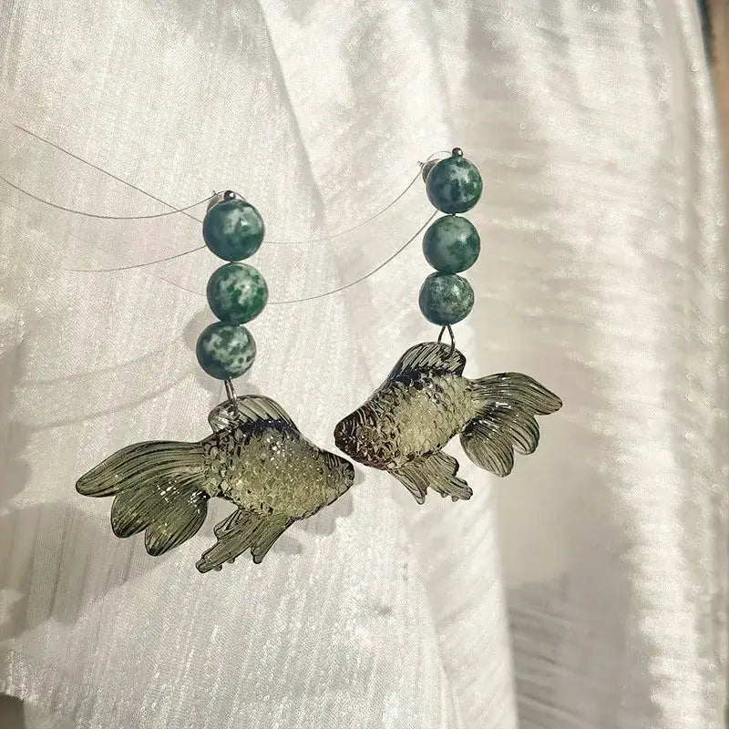 Pair of transparent goldfish pendant earrings with teal marbled bead drops