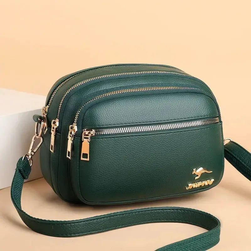 Green leather crossbody bag with multiple zip pockets and gold-tone hardware by Simples Market