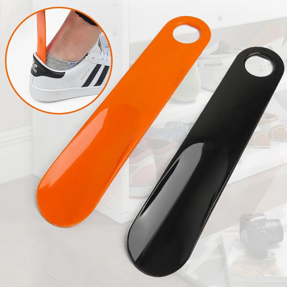 Shoe Horns set, orange and black plastic spoon-shaped lifters with ring handles, by Simples Market, 2-piece.