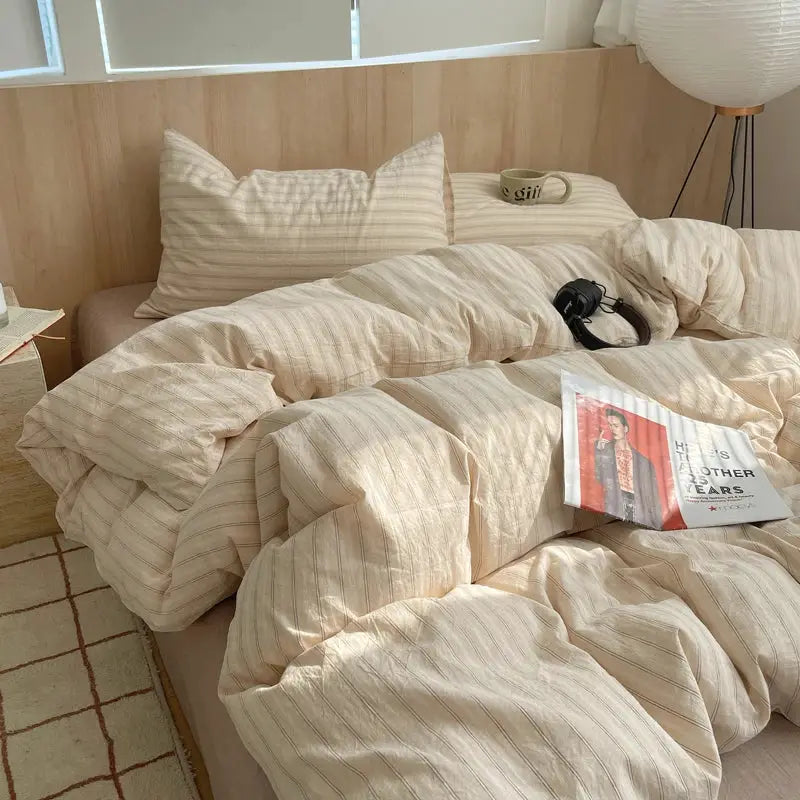 Beige striped 100% cotton duvet cover set with matching pillowcases on a bed