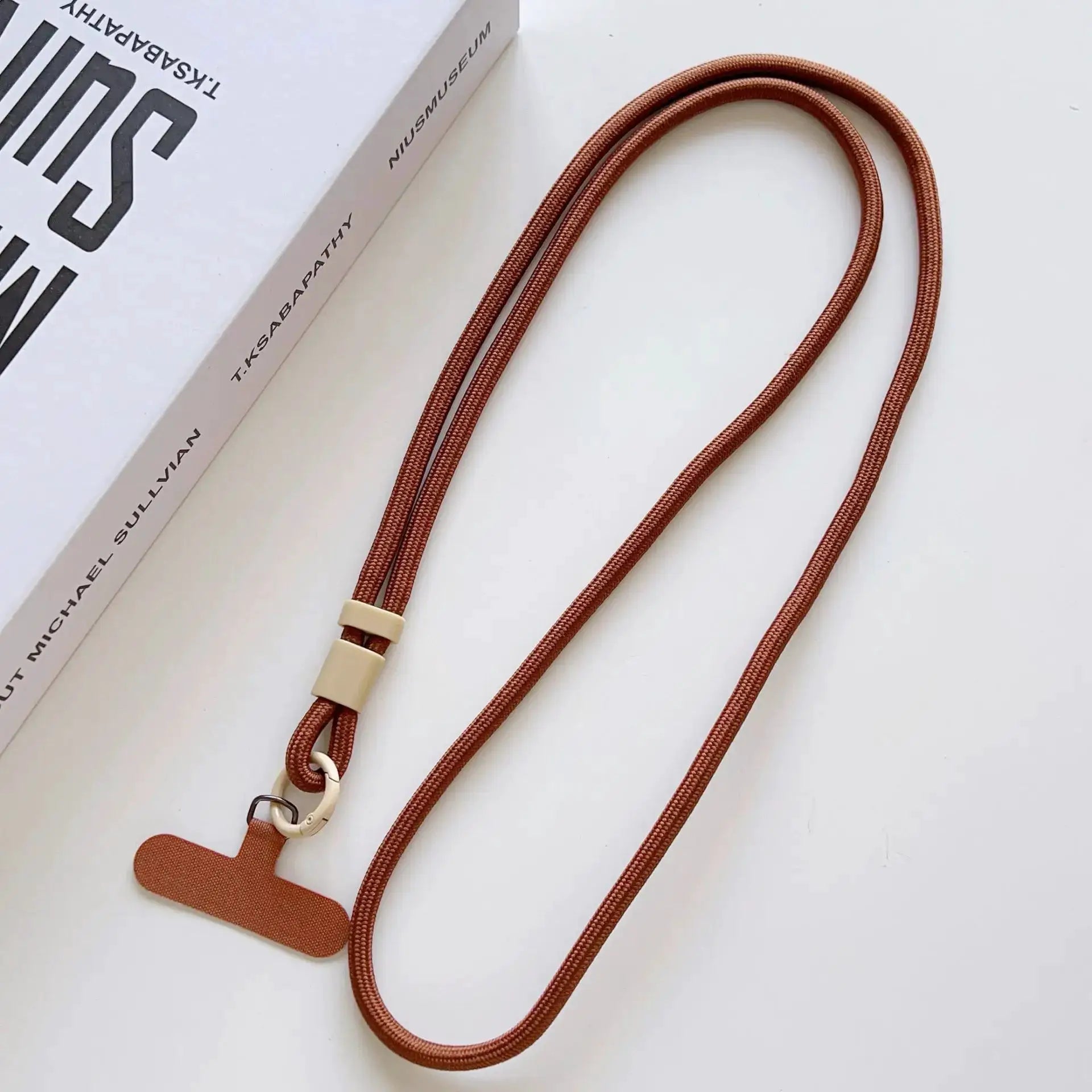 Copper brown mobile phone lanyard with beige hardware, long crossbody rope strap