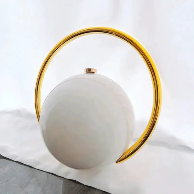 Luxury acrylic evening clutch with white spherical body and gold ring handle