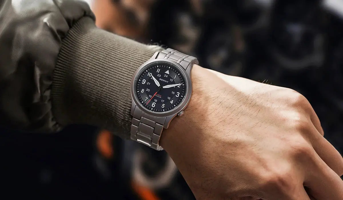 BERNY titanium men's field watch on a wrist with a black dial and metal bracelet