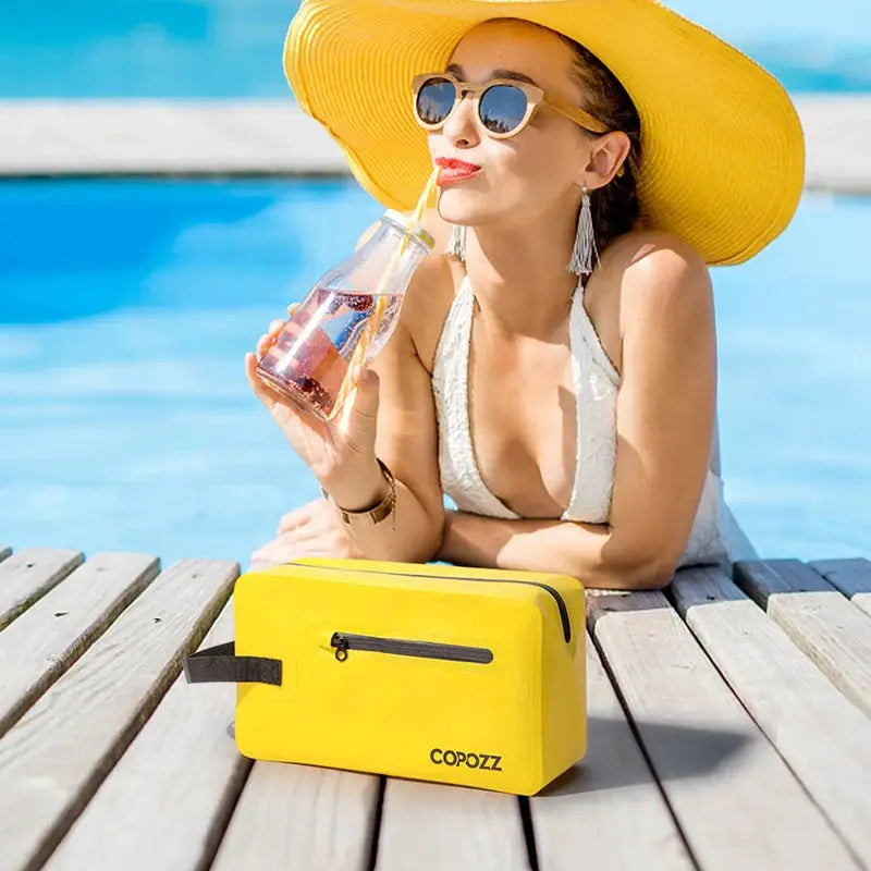Yellow gym bag COPOZZ with black zipper and handle on a poolside wooden deck
