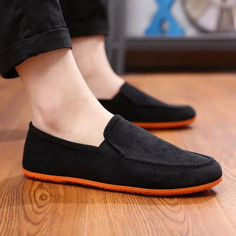 Men's black fabric loafers with orange sole, slip-on driving shoes.