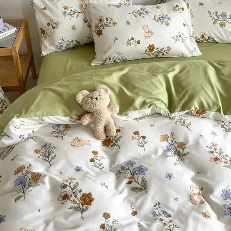 Pink floral bedding set on bed with a green sheet; duvet cover and matching pillowcases