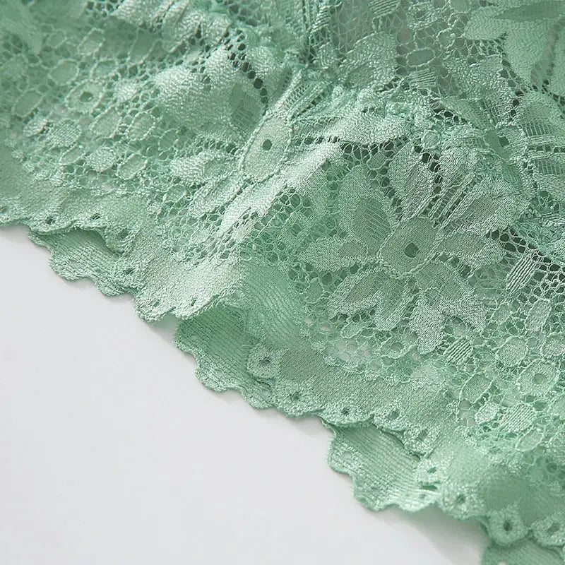 Mint green lace bralette fabric close-up with floral pattern