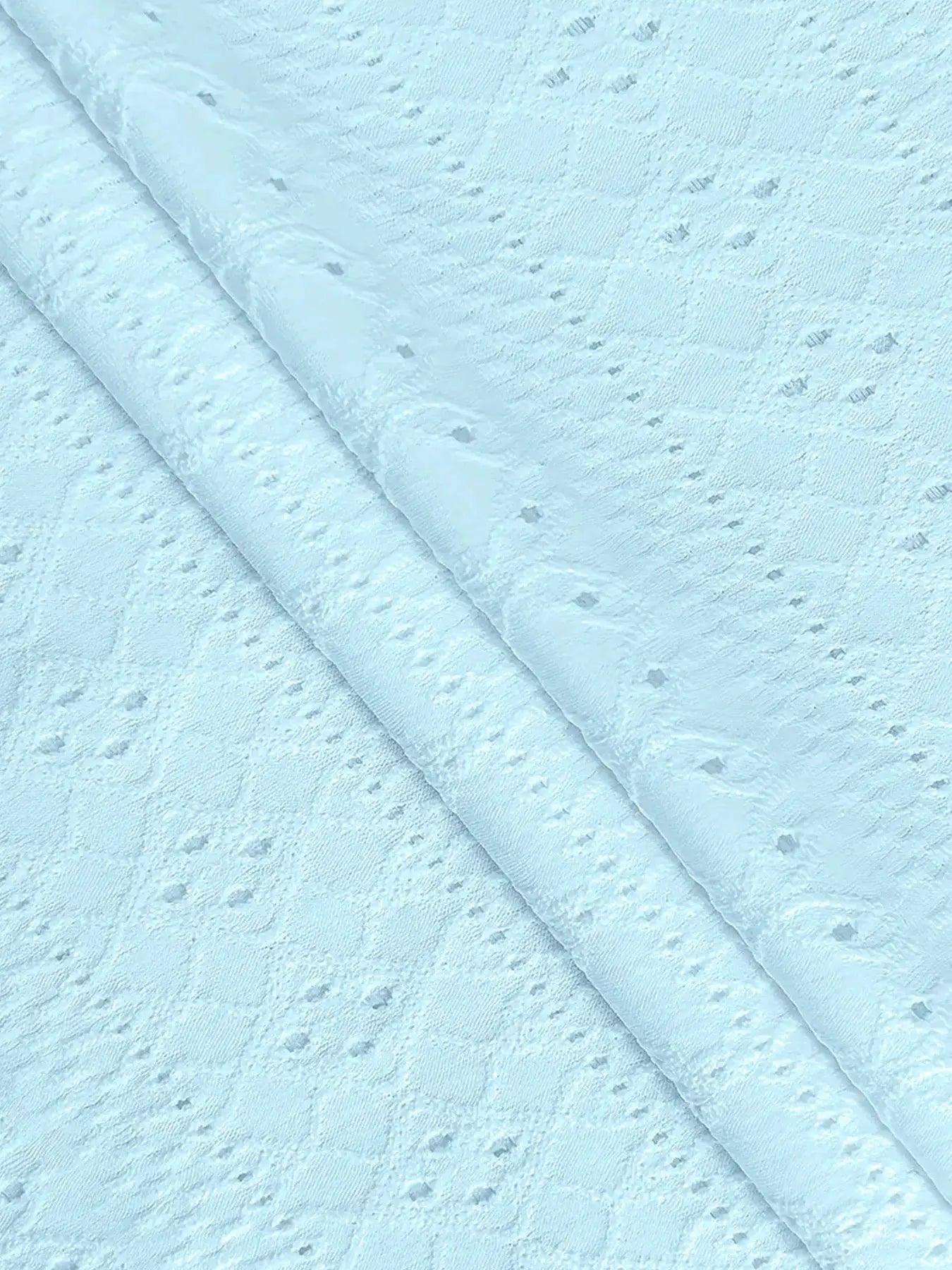 Blue lace fabric close-up with dotted pattern and rolled edges
