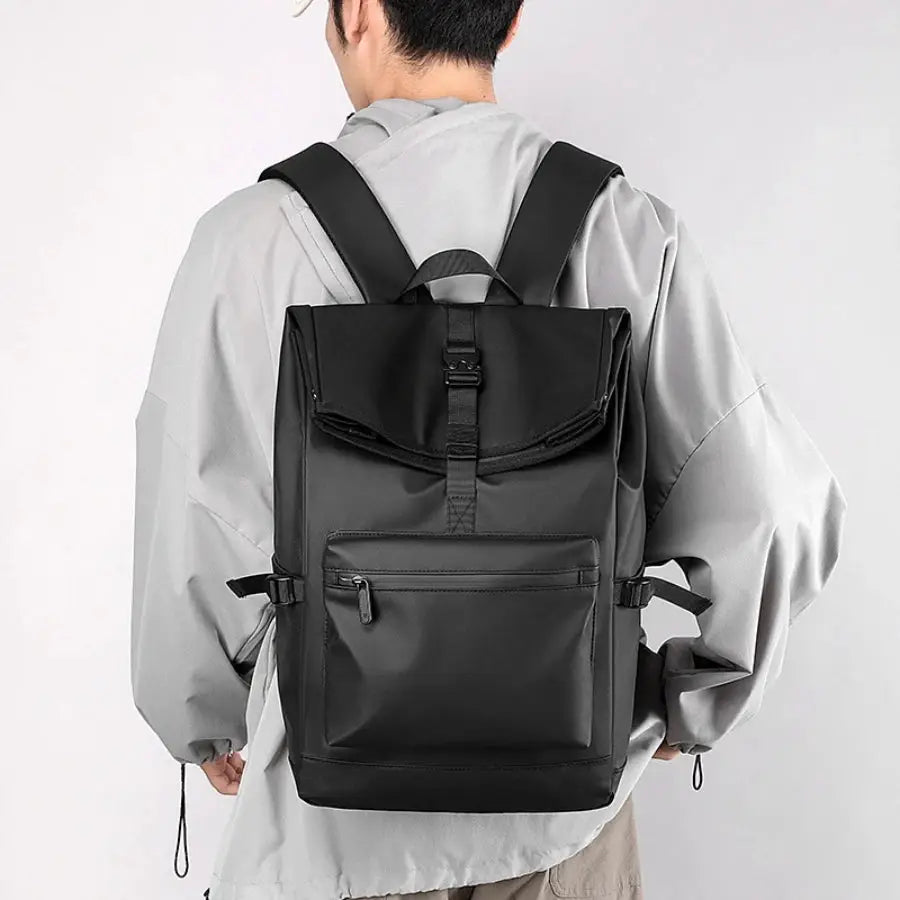 Black 17-inch urban men's business backpack with top flap buckle, front zip pocket, and side compression straps
