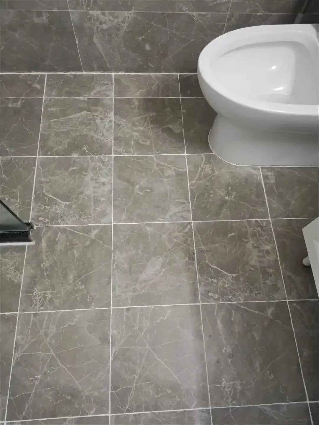 Waterproof Tile Marker Grout Pen for floor and bathroom wall seams; gray marble tile floor and white toilet.