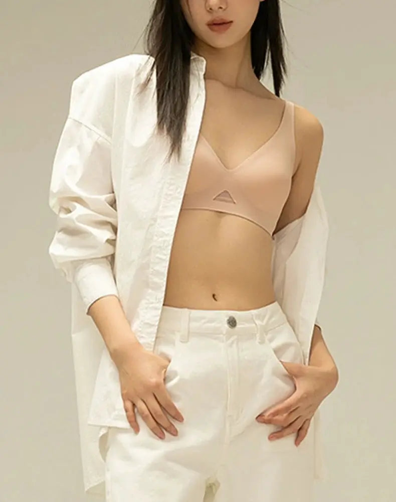 Simples Market wire-free nude bralette with seamless triangle cups, worn under a white shirt.