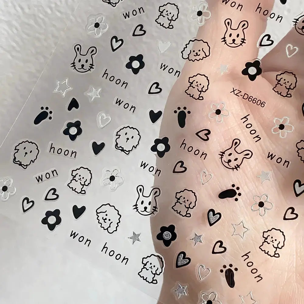 Simples Market 12-sheet cartoon nail sticker set with black outlined animal icons, paw prints, hearts, and flowers on a clear sheet