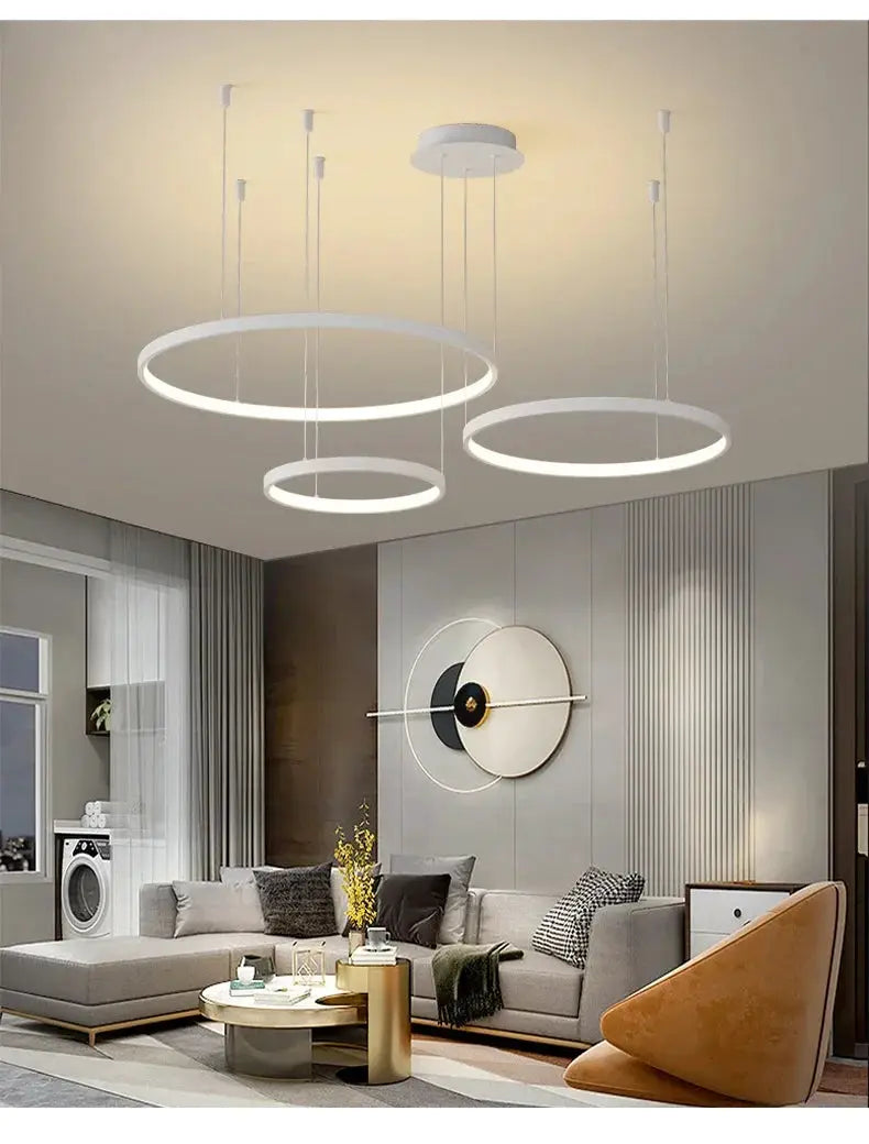 Minimalist pendant lights: three white acrylic LED ring chandeliers for modern living rooms.