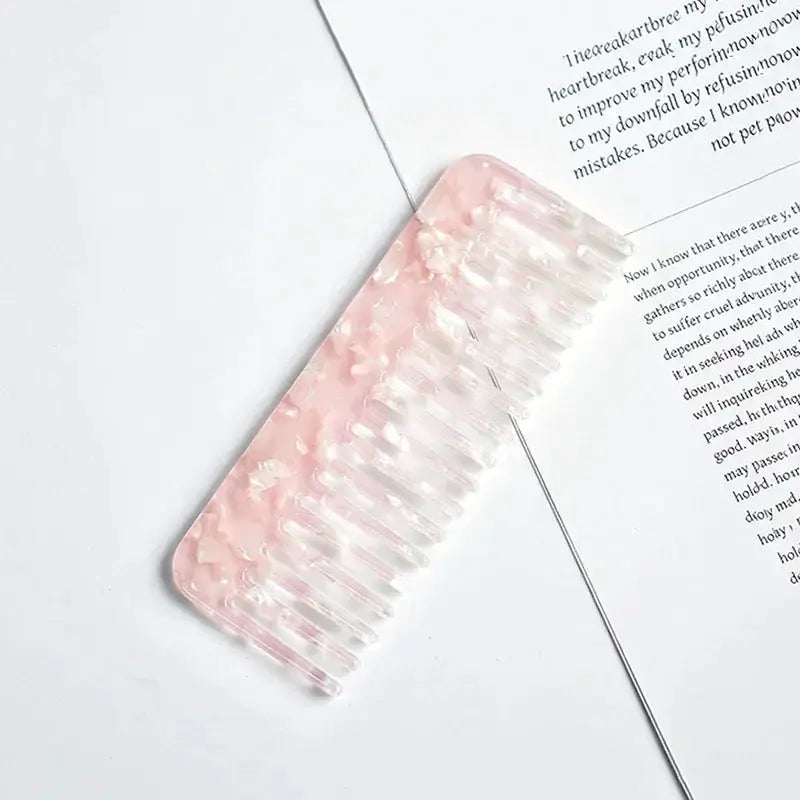 Wide-tooth pink acetate hair comb with clear teeth for styling and detangling