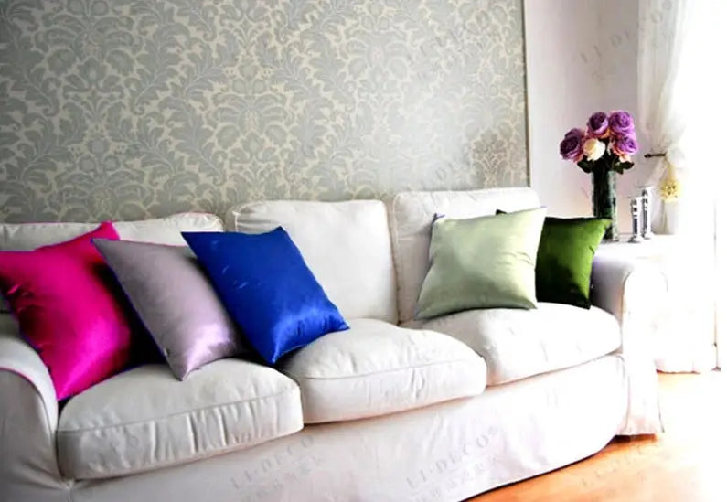Simples Market satin pillow covers on a white sofa; six colorful cushions.