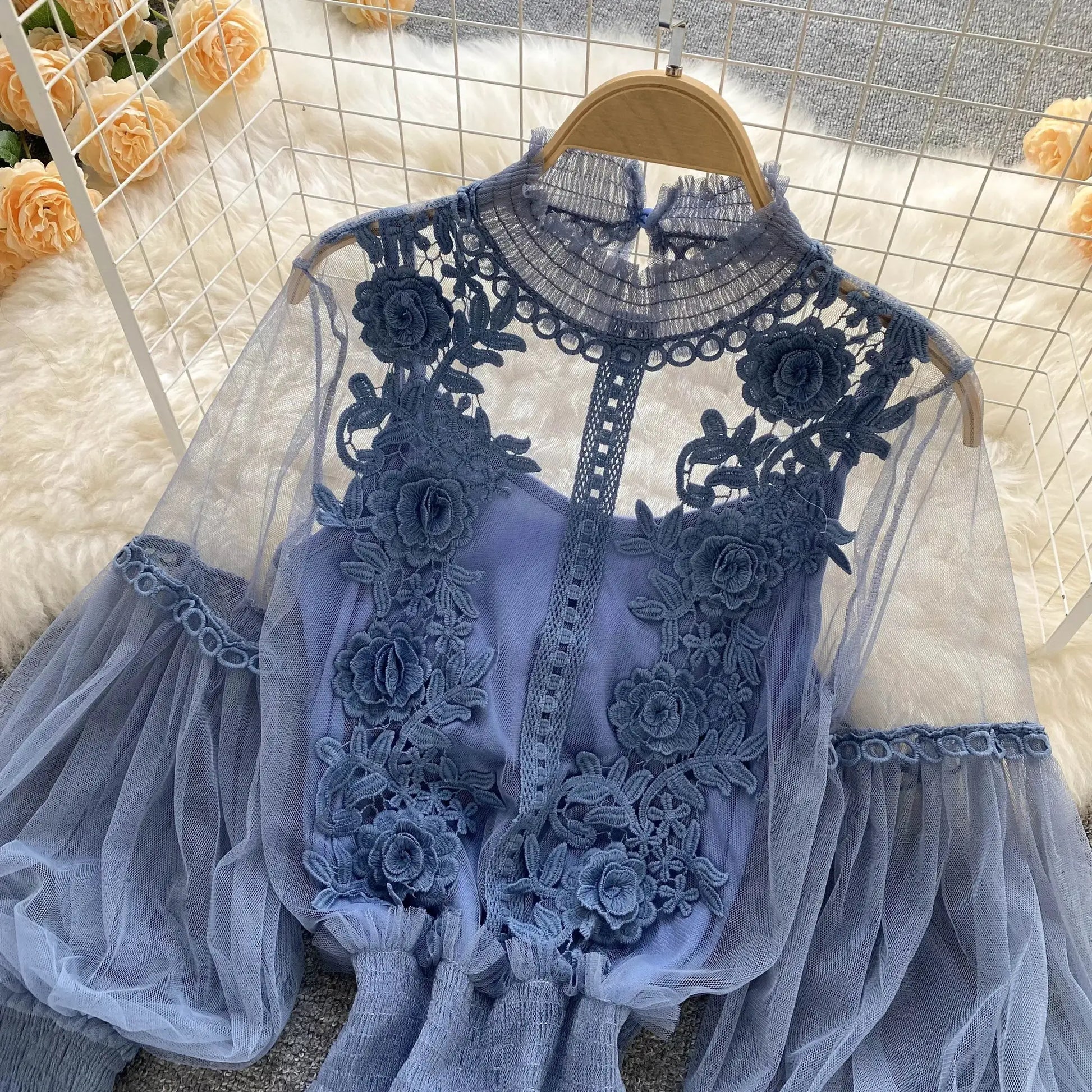 Lace puff long-sleeve blouse in blue with sheer lace, displayed on a hanger by Simples Market